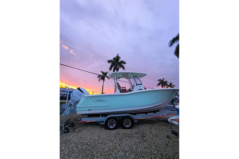 Slide: The Image of 2024 Pioneer 270 Pelagic boat on trailer at sunset with palm trees. - 76