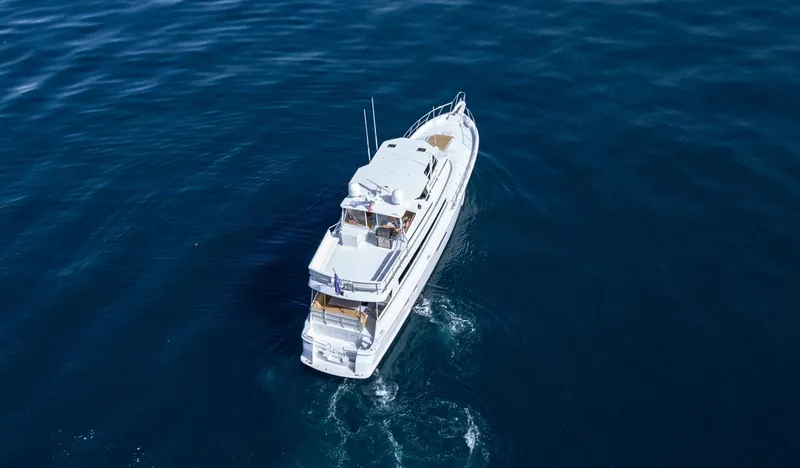 Slide: The Image of Aerial view of 1999 Hatteras 74 Sport Deck Motor Yacht cruising on open water. - 10