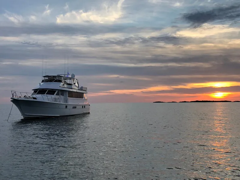 Slide: The Image of 1999 Hatteras 74 Sport Deck Motor Yacht at sunset on calm waters. - 11