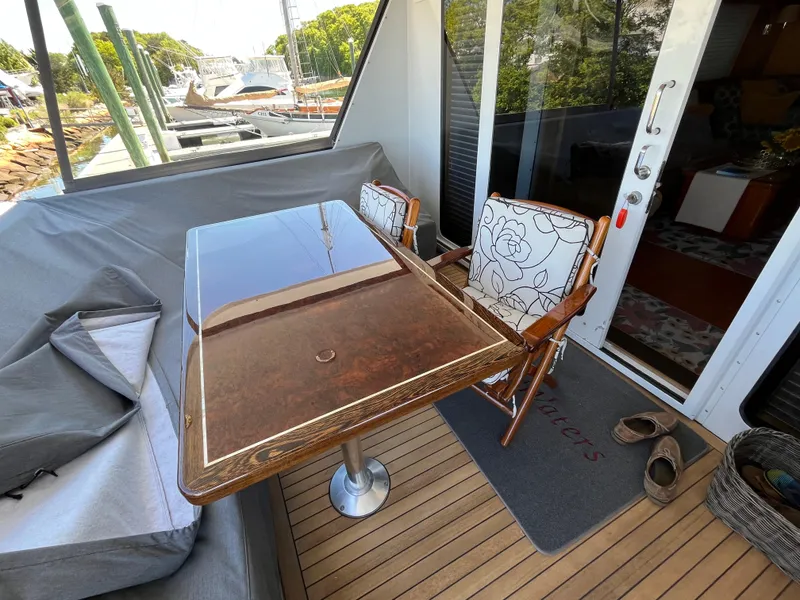Slide: The Image of Outdoor seating on 1999 Hatteras 74 Sport Deck Motor Yacht with wooden table and chairs. - 15