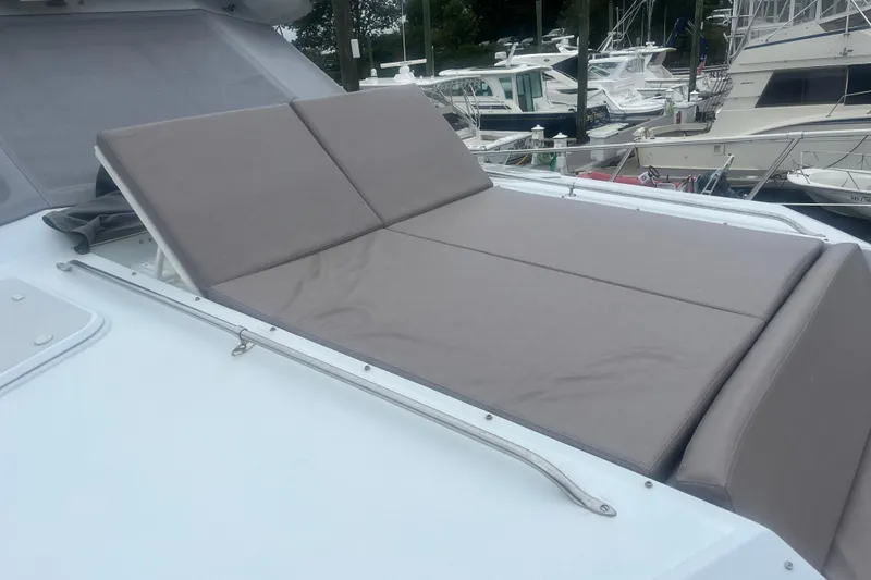 Slide: The Image of Sunbathing deck on 1999 Hatteras 74 Sport Deck Motor Yacht, docked with other boats. - 161