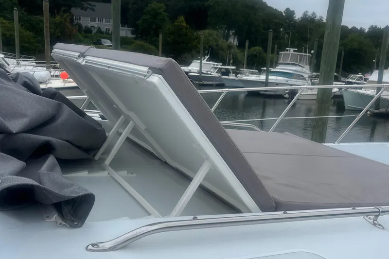 Slide: The Image of 1999 Hatteras 74 Sport Deck Motor Yacht sunpad with adjustable backrest at marina. - 164