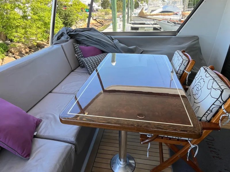 Slide: The Image of Luxurious seating area on 1999 Hatteras 74 Sport Deck Motor Yacht with polished table. - 17