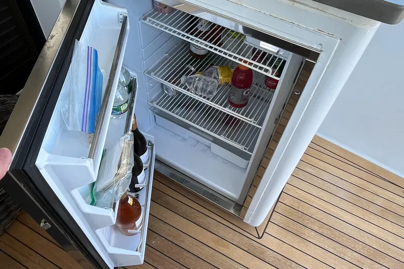 Slide: The Image of Open fridge on 1999 Hatteras 74 Sport Deck Motor Yacht with drinks and snacks inside. - 19