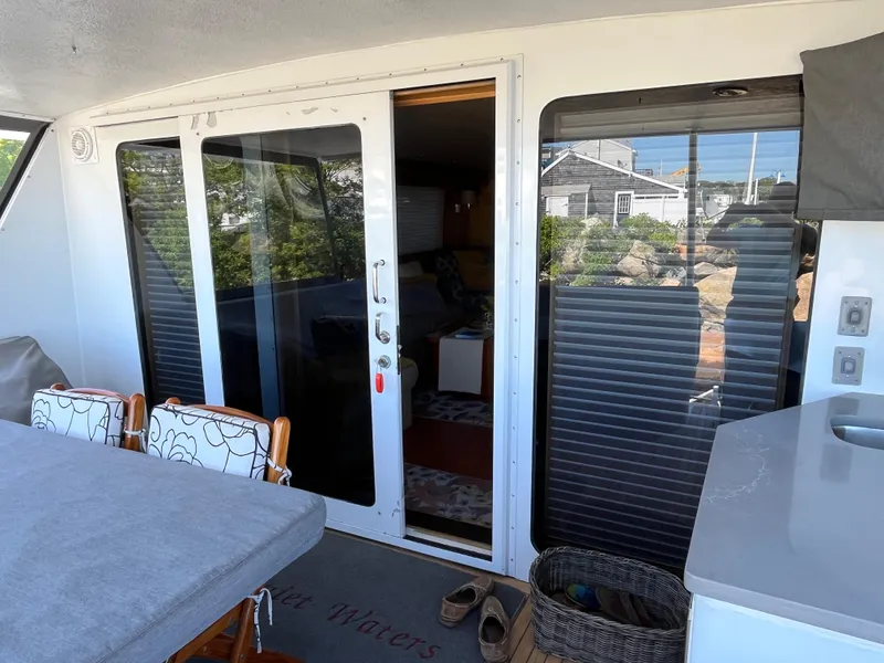Slide: The Image of 1999 Hatteras 74 Sport Deck Motor Yacht interior with sliding glass doors and outdoor seating area. - 22