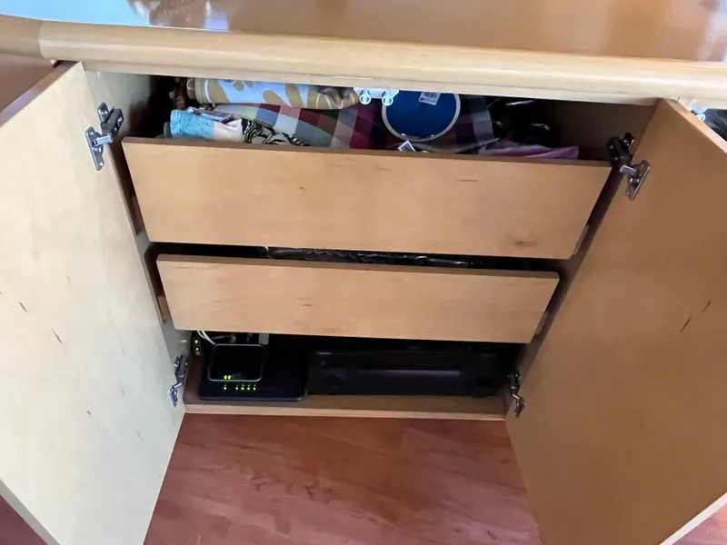 Slide: The Image of Open wooden cabinet with shelves, containing various items, inside a 1999 Hatteras 74 Sport Deck Motor Yacht. - 30