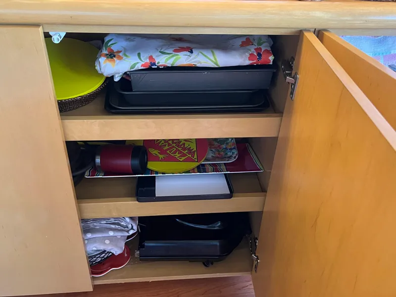 Slide: The Image of Cabinet storage with kitchen items on a 1999 Hatteras 74 Sport Deck Motor Yacht. - 31
