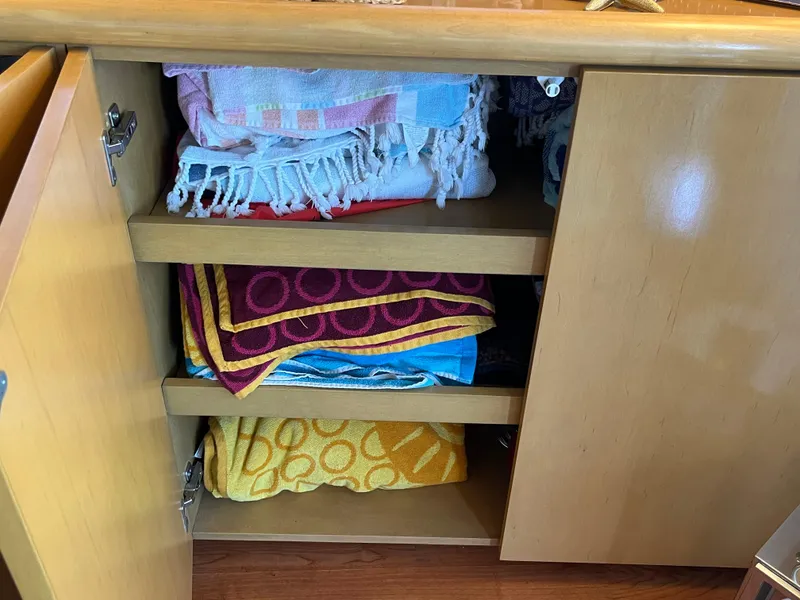 Slide: The Image of Cabinet with neatly stacked colorful towels on a 1999 Hatteras 74 Sport Deck Motor Yacht. - 32