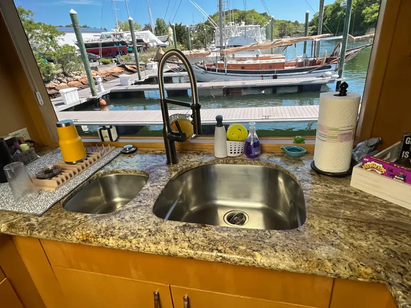 Slide: The Image of Kitchen sink area on a 1999 Hatteras 74 Sport Deck Motor Yacht with marina view. - 38