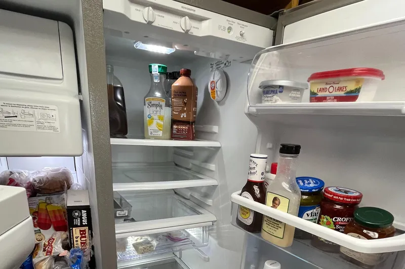 Slide: The Image of Open refrigerator with various condiments and beverages inside. - 41