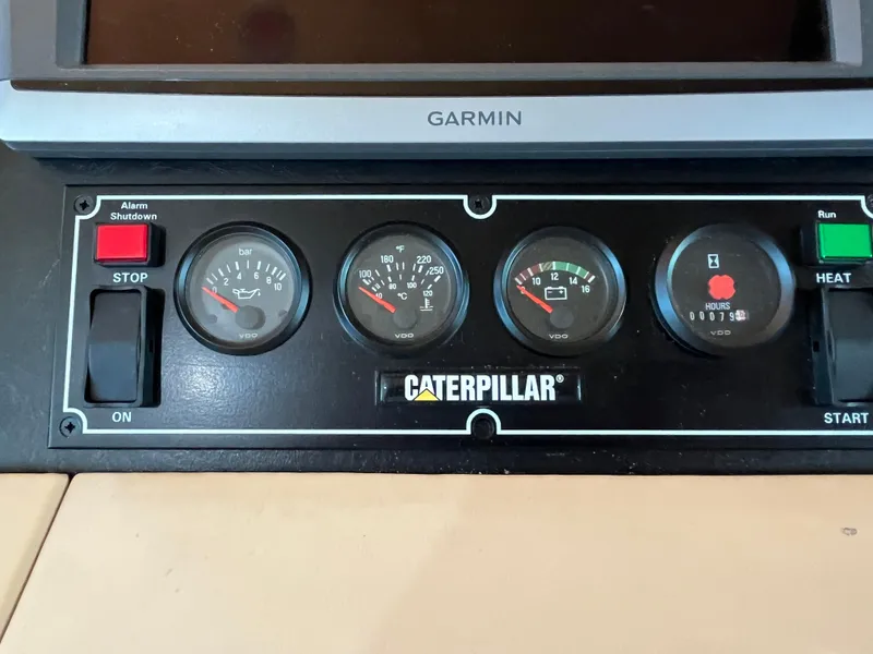 Slide: The Image of Control panel of a 1999 Hatteras 74 Sport Deck Motor Yacht with Caterpillar gauges. - 48