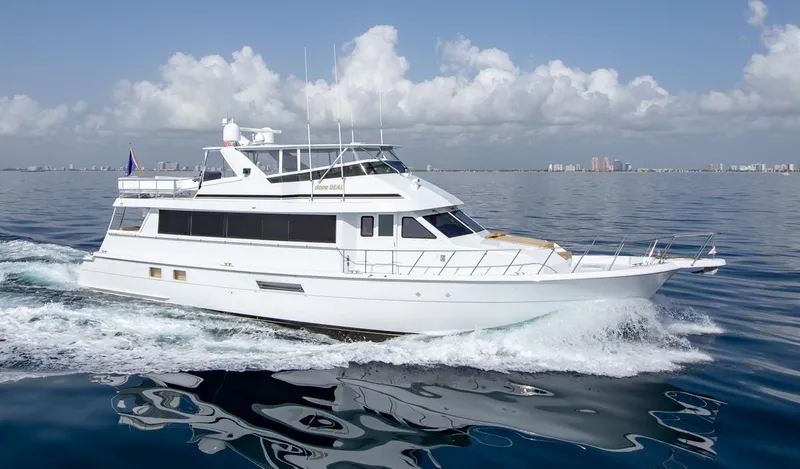 Slide: The Image of 1999 Hatteras 74 Sport Deck Motor Yacht cruising on open water. - 6