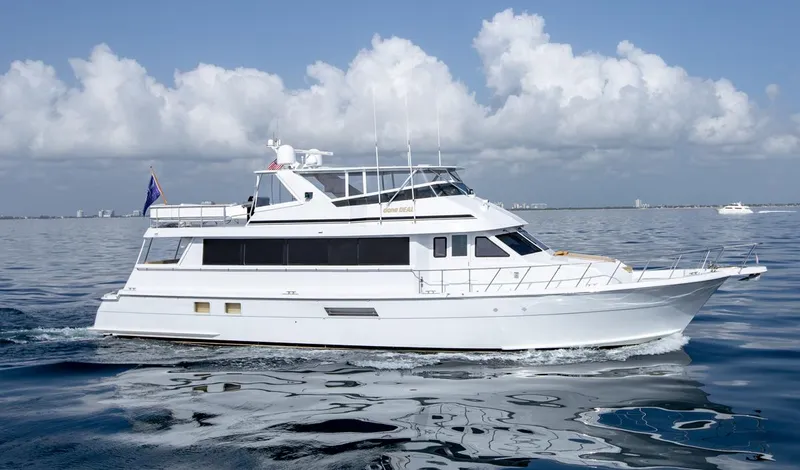 Slide: The Image of 1999 Hatteras 74 Sport Deck Motor Yacht cruising on calm waters under a blue sky. - 8