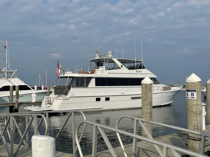 Slide: The Image of 1999 Hatteras 74 Sport Deck Motor Yacht docked at a marina. - 9