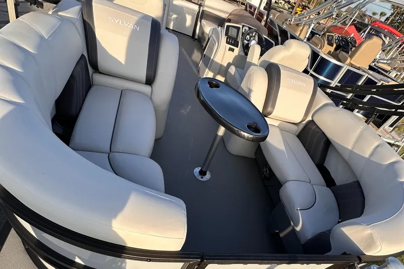 Slide: The Image of 2023 Sylvan Mirage X X3 pontoon boat interior with plush seating and table. - 4
