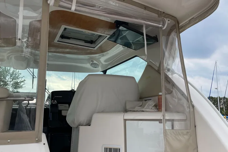 Slide: The Image of 2008 Tiara Yachts 4300 Sovran cockpit interior with covered seating and clear enclosure. - 13