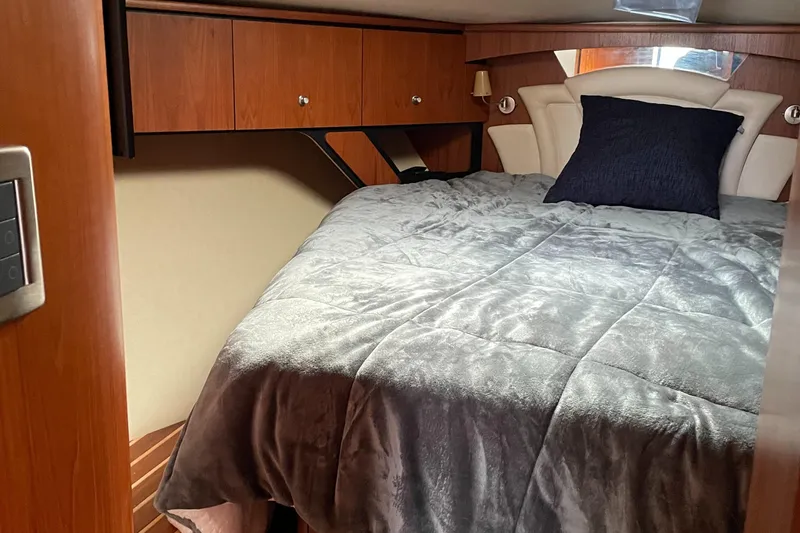 Slide: The Image of 2008 Tiara Yachts 4300 Sovran cabin with bed, wooden cabinets, and modern decor. - 17