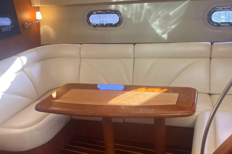 Slide: The Image of 2008 Tiara Yachts 4300 Sovran interior with white leather seating and wooden table - 18