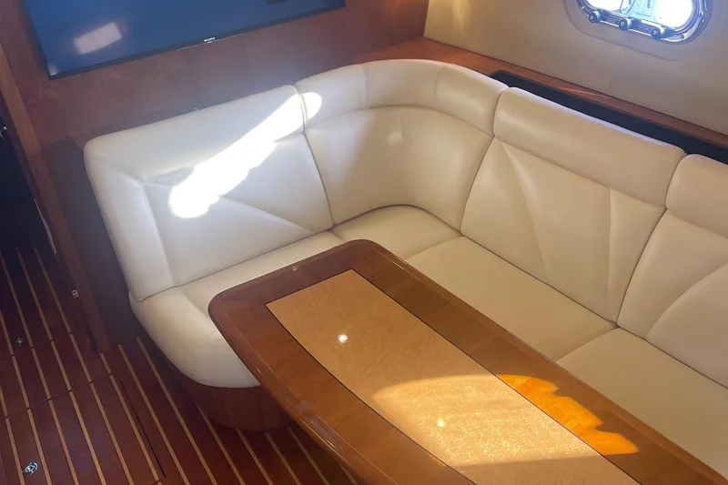 Slide: The Image of 2008 Tiara Yachts 4300 Sovran interior with white leather seating and wooden table. - 19