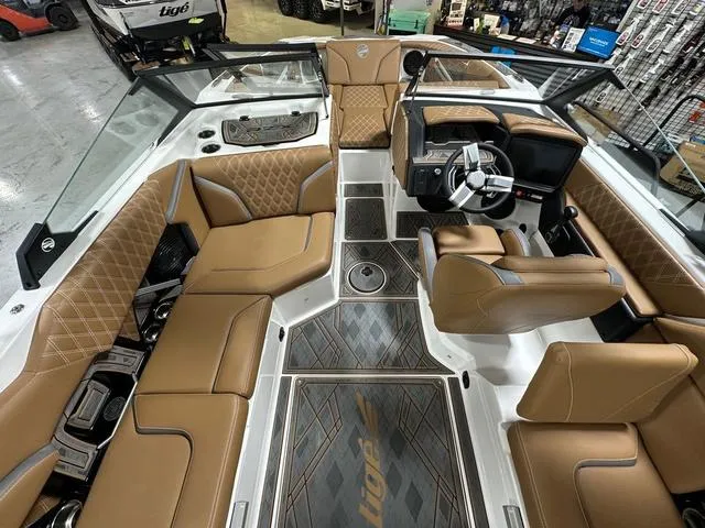 Slide: The Image of 2024 Tigé 22RZX boat interior with luxurious tan seating and modern dashboard. - 11