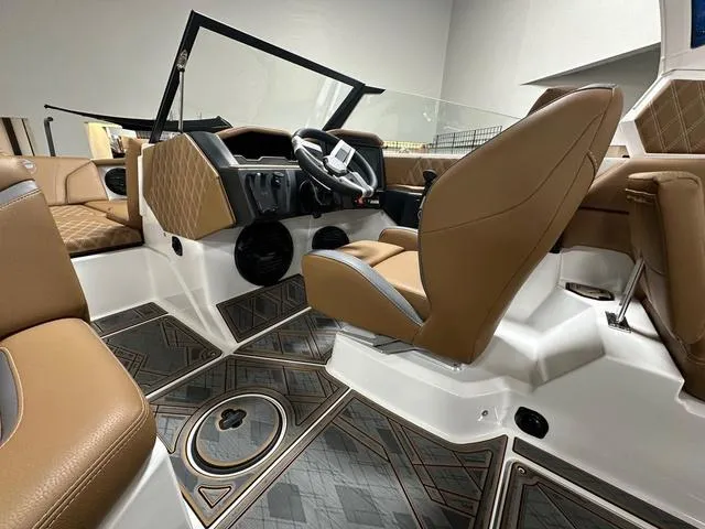 Slide: The Image of 2024 Tigé 22RZX boat interior with luxurious brown seating and modern dashboard design. - 12