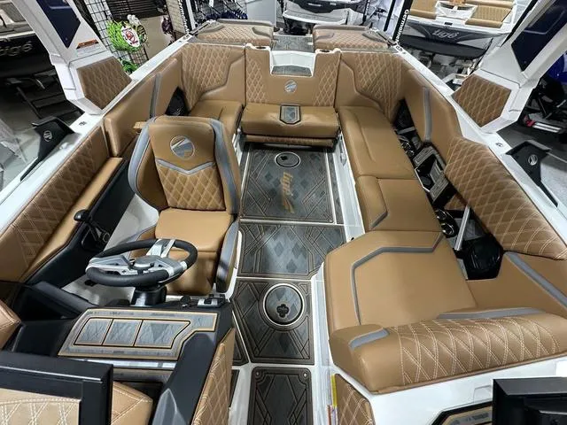 Slide: The Image of 2024 Tigé 22RZX boat interior with luxurious tan seating and modern dashboard design. - 16