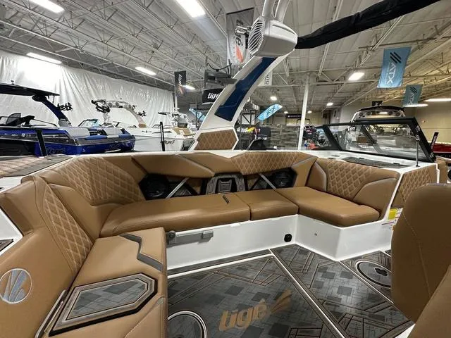 Slide: The Image of 2024 Tigé 22RZX boat interior with luxurious tan seating and modern design in showroom. - 9