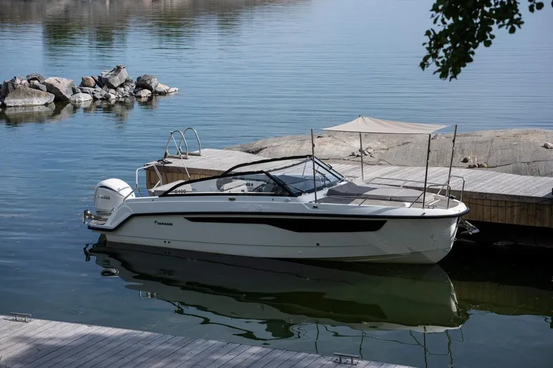 Slide: The Image of 2024 Yamarin 80 boat docked by a serene lakeside. - 0
