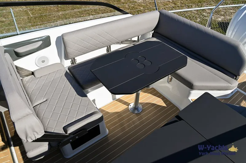 Slide: The Image of Yamarin 80 2024 boat interior with grey cushioned seating and black table. - 18