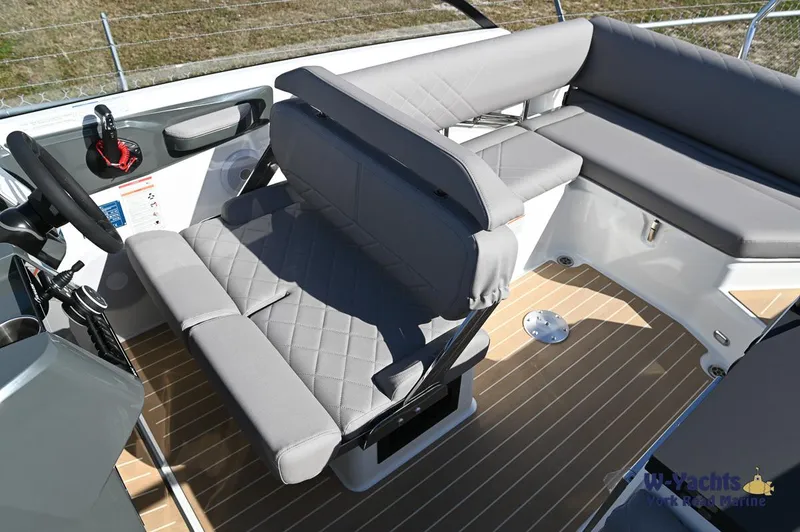 Slide: The Image of Yamarin 80 boat interior, 2024 model, featuring grey cushioned seating and wooden flooring. - 21