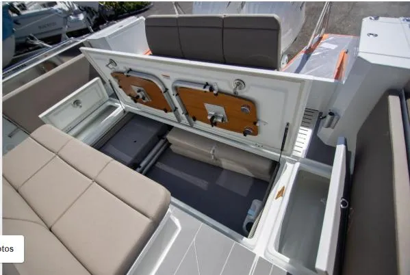 Slide: The Image of 2025 Quarken 35 boat interior with open storage compartments and cushioned seating. - 11