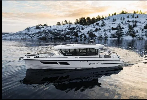Slide: The Image of 2024 Quarken 35 boat cruising on a serene lake with snowy hills in the background. - 5