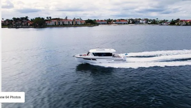 Slide: The Image of 2025 Quarken 35 boat cruising on a scenic lake with waterfront homes in the background. - 6