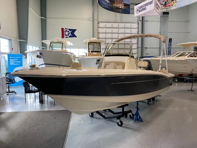 Slide: The Image of 2025 Scout 195 Sportfish boat on display in a showroom. - 2