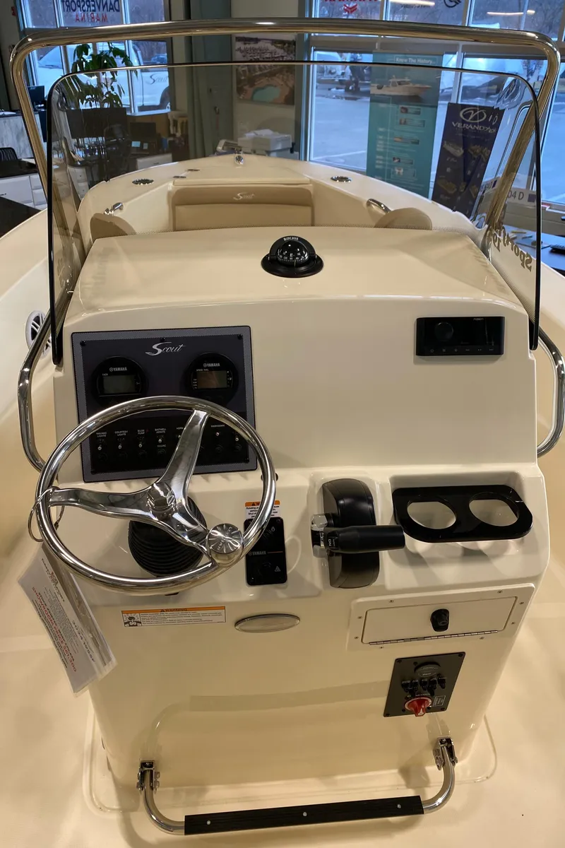 Slide: The Image of 2025 Scout 195 Sportfish boat dashboard with steering wheel and controls. - 7
