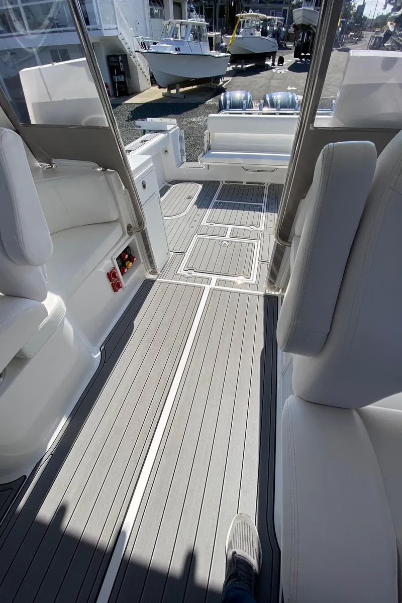 Slide: The Image of 2022 NorthCoast 315 boat interior with gray flooring and white seating. - 12