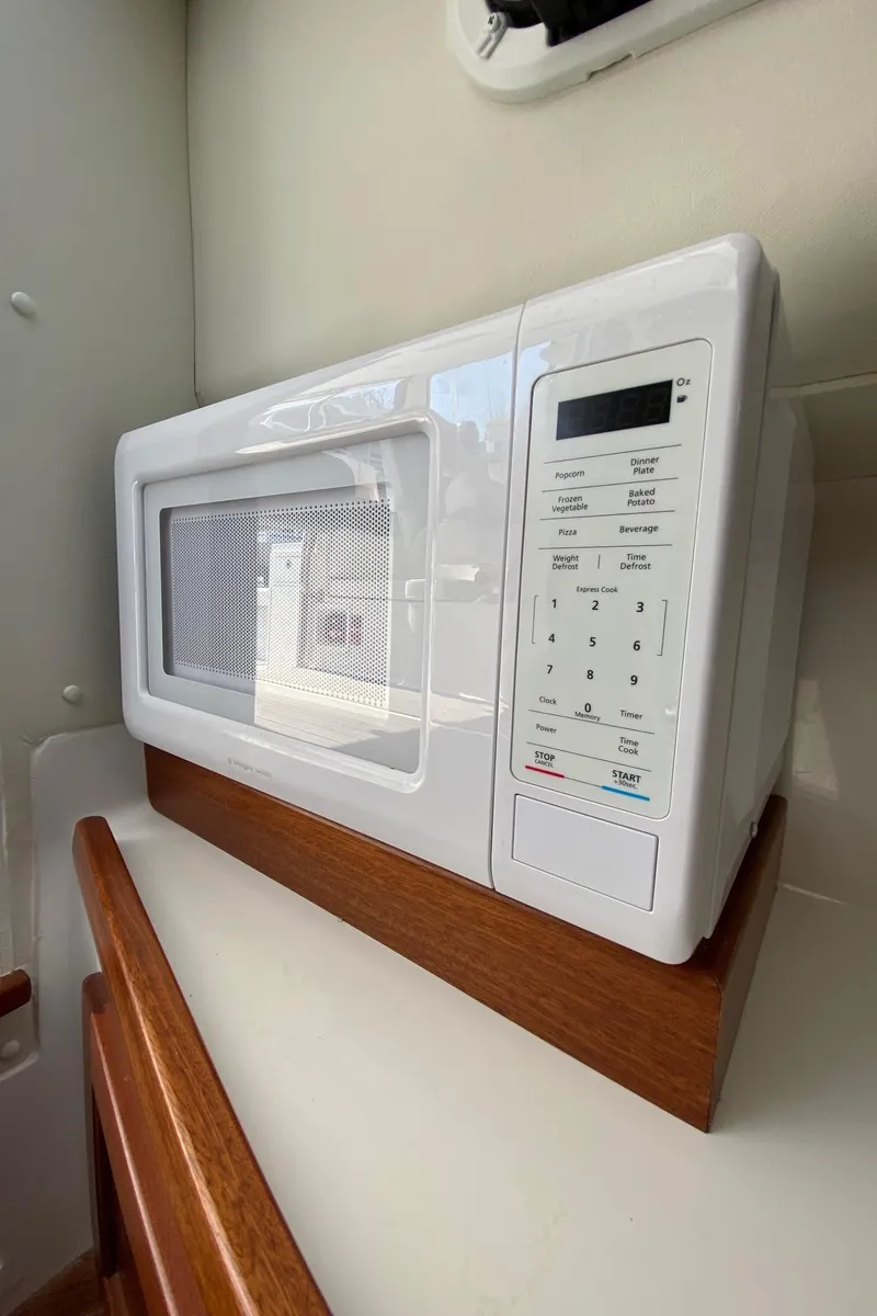 Slide: The Image of White microwave in the kitchen area of a 2022 NorthCoast 315 boat. - 21