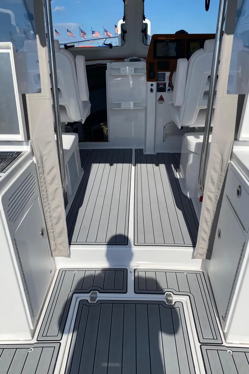 Slide: The Image of 2022 NorthCoast 315 boat interior with gray flooring and white seating. - 5