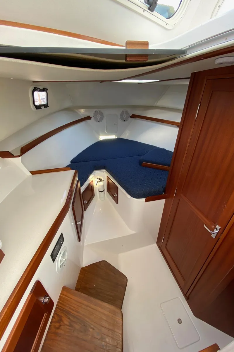 Slide: The Image of Interior cabin of 2022 NorthCoast 315 boat with wooden finishes and blue upholstery. - 23