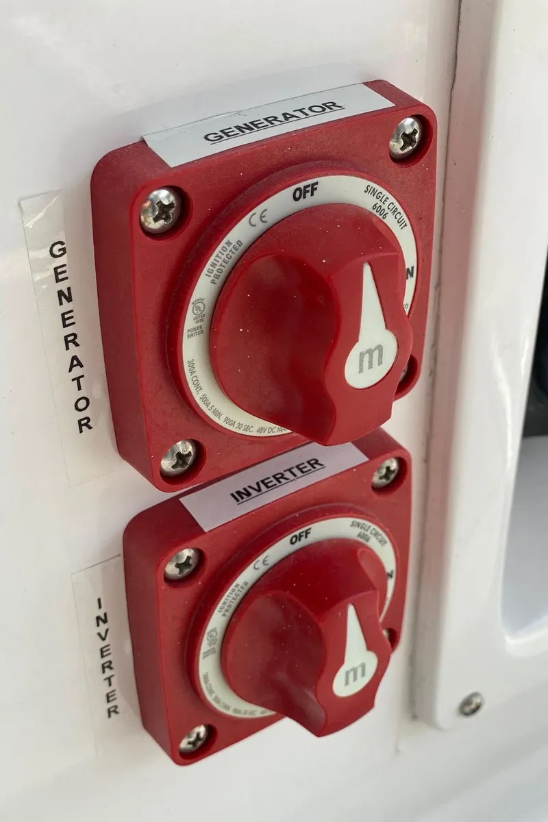 Slide: The Image of Red generator and inverter switches on a 2022 NorthCoast 315 boat. - 25