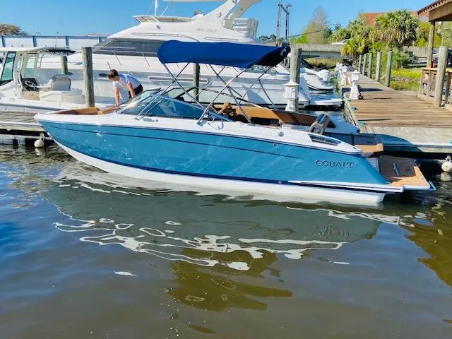 Slide: The Image of 2023 Cobalt R6 boat docked at marina with blue canopy. - 1