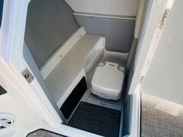 Slide: The Image of 2023 Cobalt R6 boat interior with compact toilet and storage area. - 19