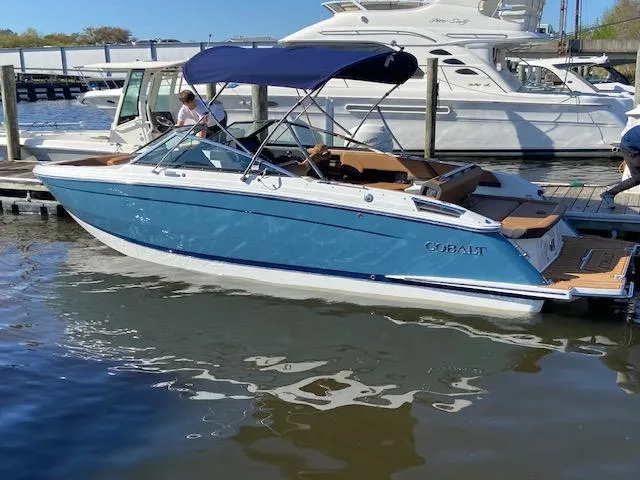Slide: The Image of 2023 Cobalt R6 boat docked in marina with blue canopy. - 30