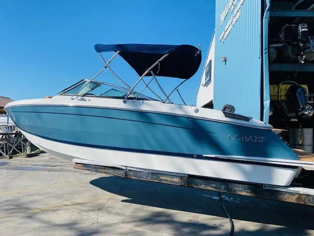 Slide: The Image of 2023 Cobalt R6 boat with blue hull and canopy in marina. - 8