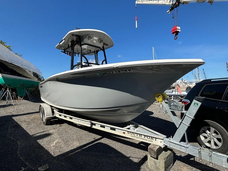 Slide: The Image of 2021 Sea Pro 219 boat on trailer, parked outdoors under clear blue sky. - 2