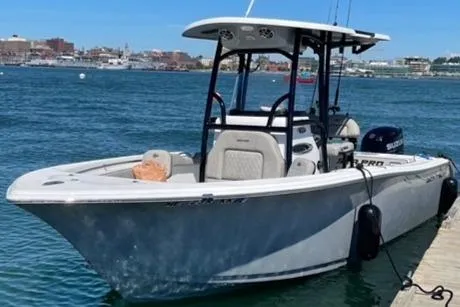 Slide: The Image of 2021 Sea Pro 219 boat docked on a sunny day, with cityscape in the background. - 9