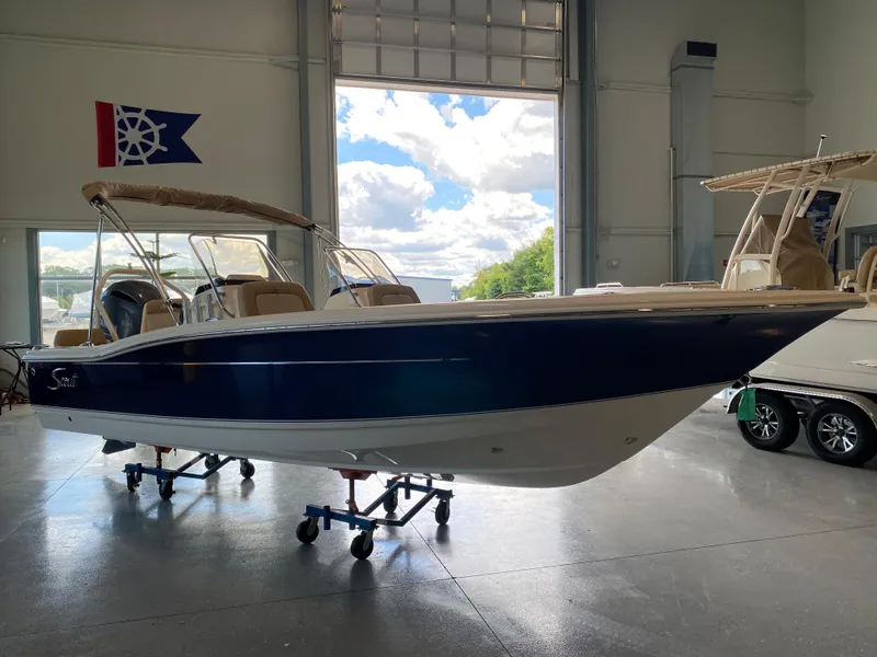 The Image of 2024 Scout 195 Dorado boat in showroom, blue and white hull, beige interior. - 0