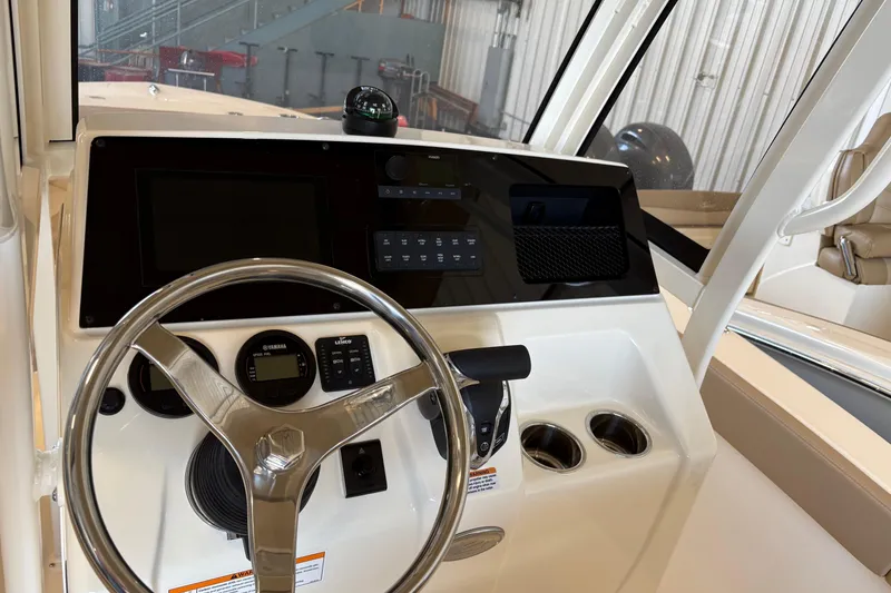 Slide: The Image of 2024 Scout 215 XSF boat dashboard with steering wheel and control panel. - 10