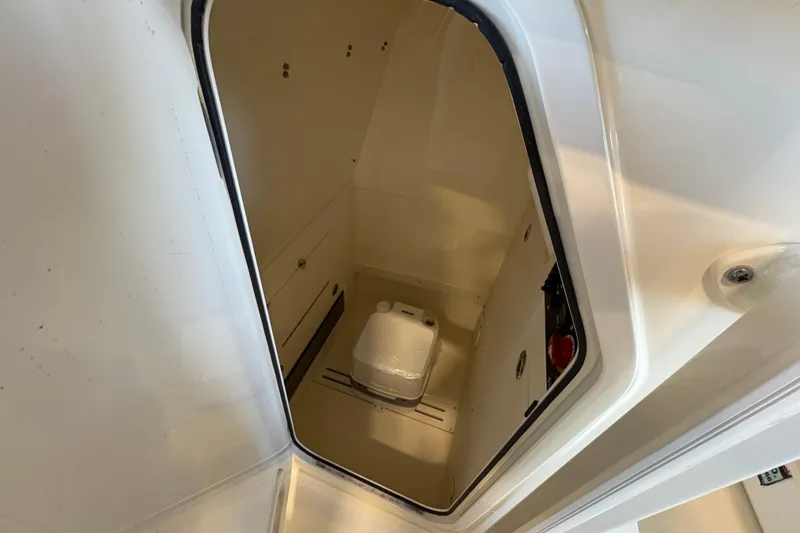 Slide: The Image of 2024 Scout 215 XSF boat interior with compact marine toilet. - 13