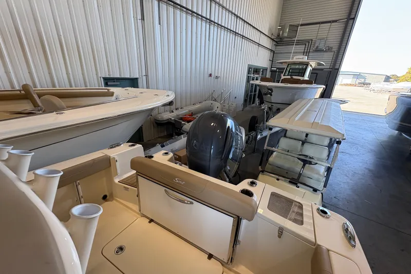Slide: The Image of 2024 Scout 215 XSF boat in a storage facility, showcasing its sleek design and modern features. - 6